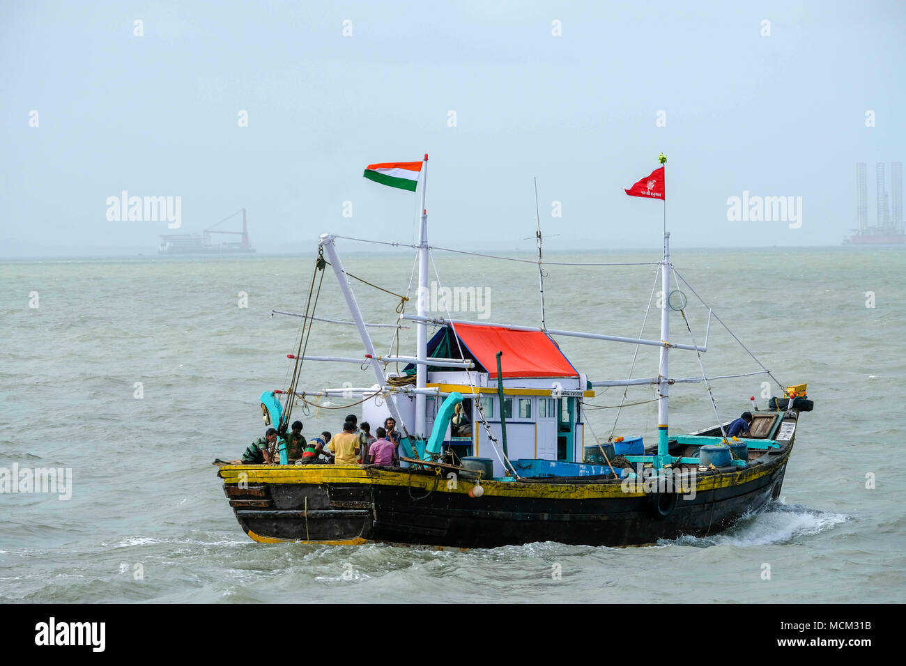 Wooden fishing vessel flying Indian flag, sailing on the Arabian sea in Mumbai, India Stock Photo