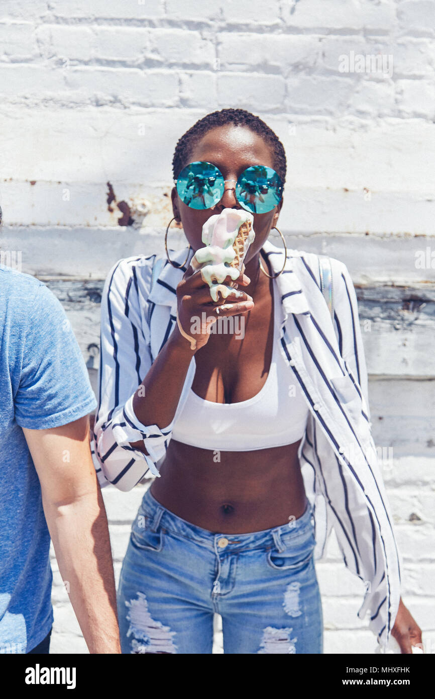 Young women eating melting ice cream cone Stock Photo