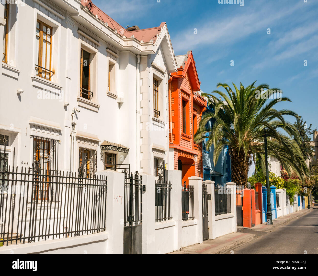 Colourful painted historic terrace houses with palm tree in front garden, Providencia, Santiago, Chile Stock Photo