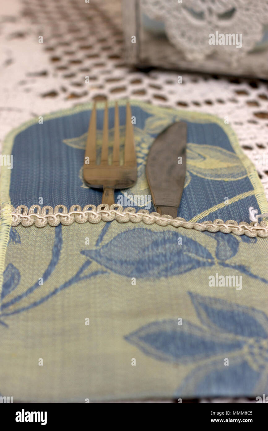 Spoon and fork in tissue wrapper on a light background Stock Photo