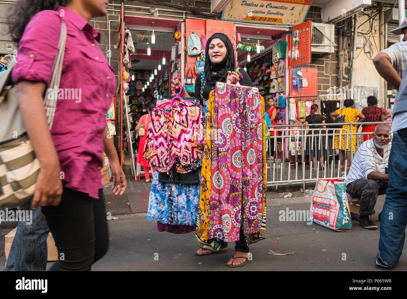 Woman street vendor selling clothes in a street market in downtown Port Louis, Mauritius Stock Photo