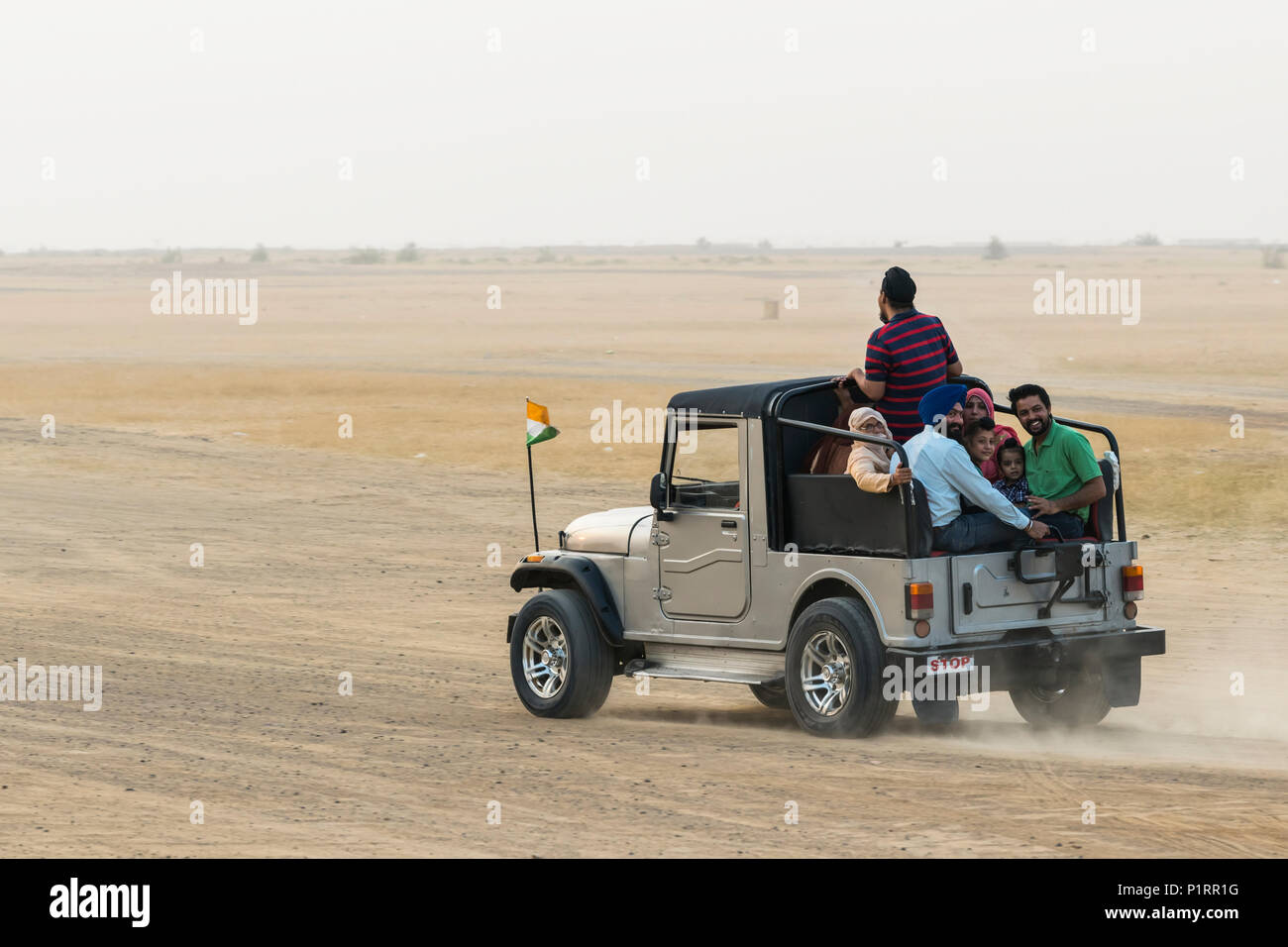 A family rides in the back of a recreational vehicle exploring the Sam sand dunes; Damodara, Rajasthan, India Stock Photo