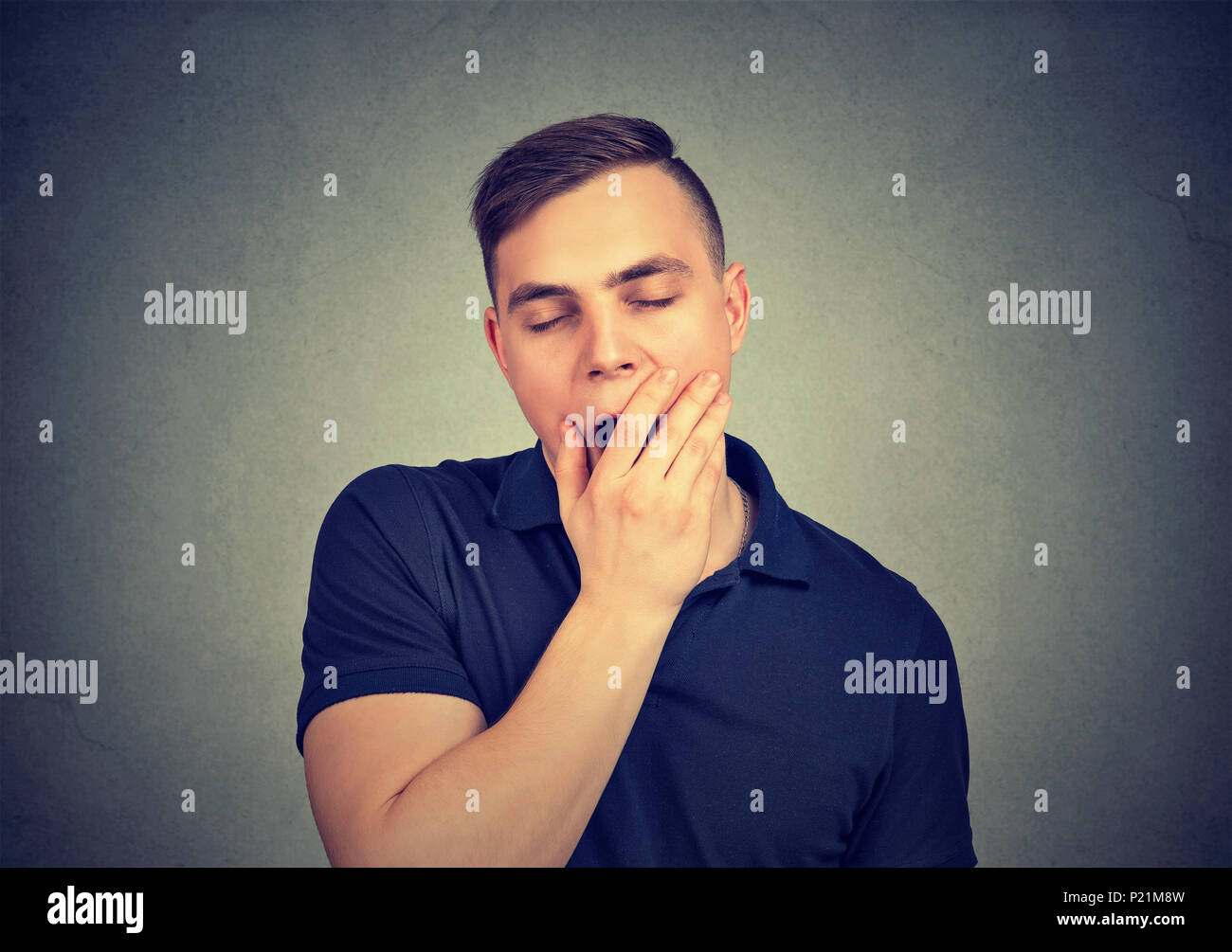 Sleepy man yawning isolated on gray background Stock Photo