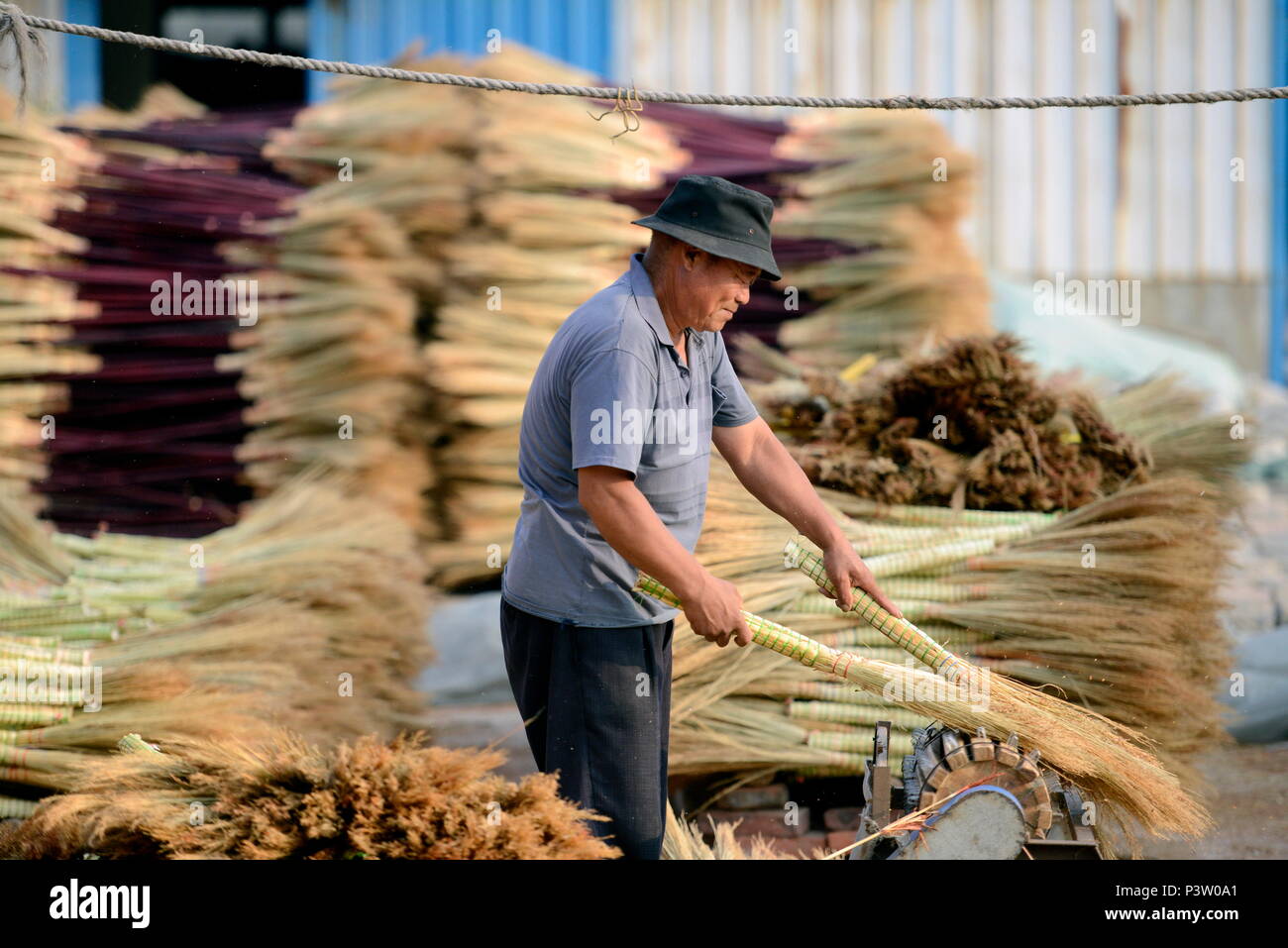 Laoting, China's Hebei Province. 19th June, 2018. A man makes a broom at a broom professional cooperative in Maozhuang Town of Laoting County, north China's Hebei Province, June 19, 2018. Maozhuang Town has a long history in handmade brooms. In recent years, the town has set up several professional cooperatives on broom to manage this specialty industry intensively. At present, brooms produced in the town have been sold to many foreign markets such as South Korea and Japan, with annual export earnings reaching over 20 million yuan (3.09 mln U.S. dollars). Credit: Mu Yu/Xinhua/Alamy Live News Stock Photo