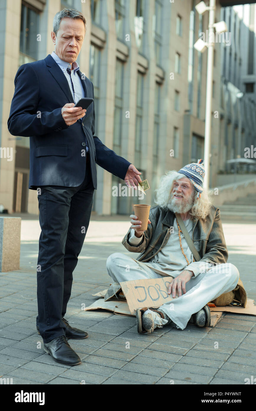 lderly rich businessman giving some money to poor man Stock Photo