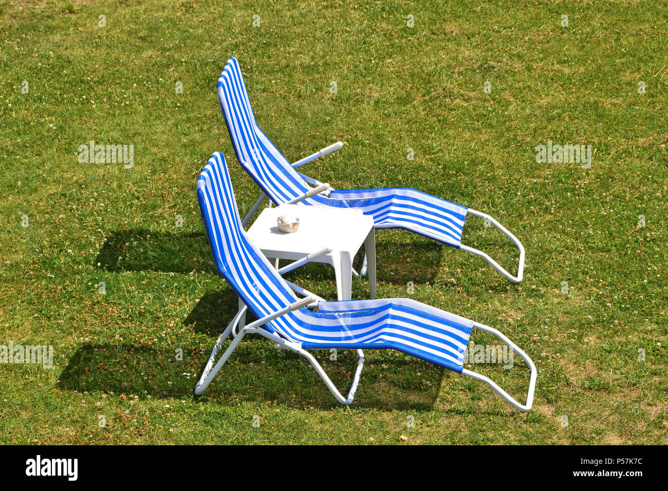 Deckchairs on a meadow in summer Stock Photo