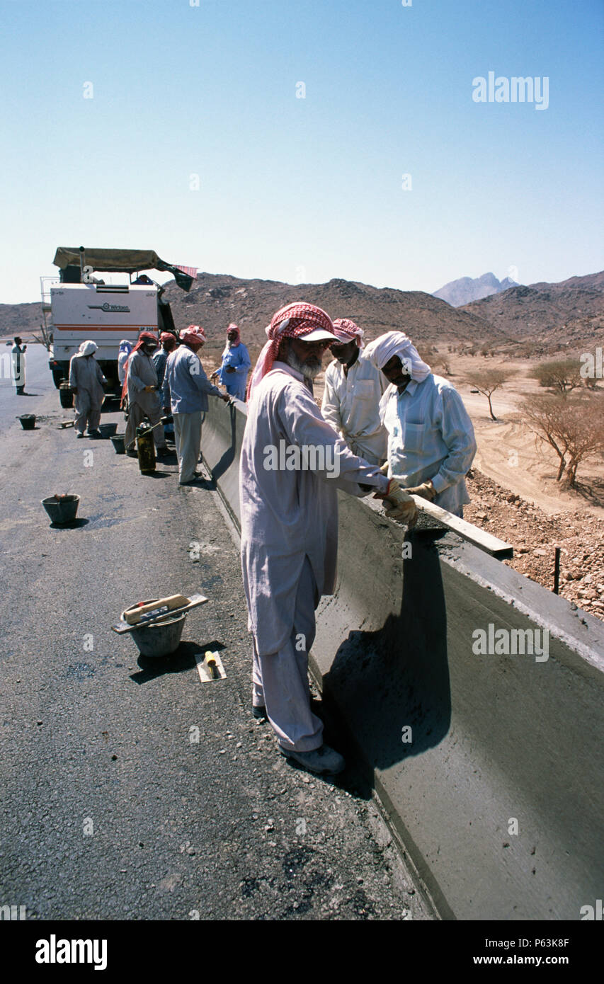 Slipforming road barrier on the Medina Yanbu section - trowel finishing work on the still wet concrete -- Jeddah to Medina highway, Saudi Arabia Stock Photo