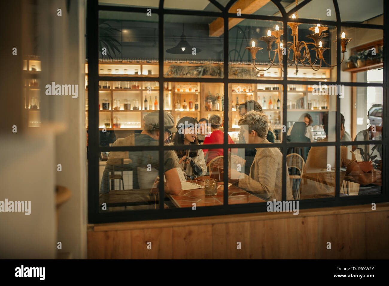 Smiling friends ordering drinks inside of a trendy bar Stock Photo