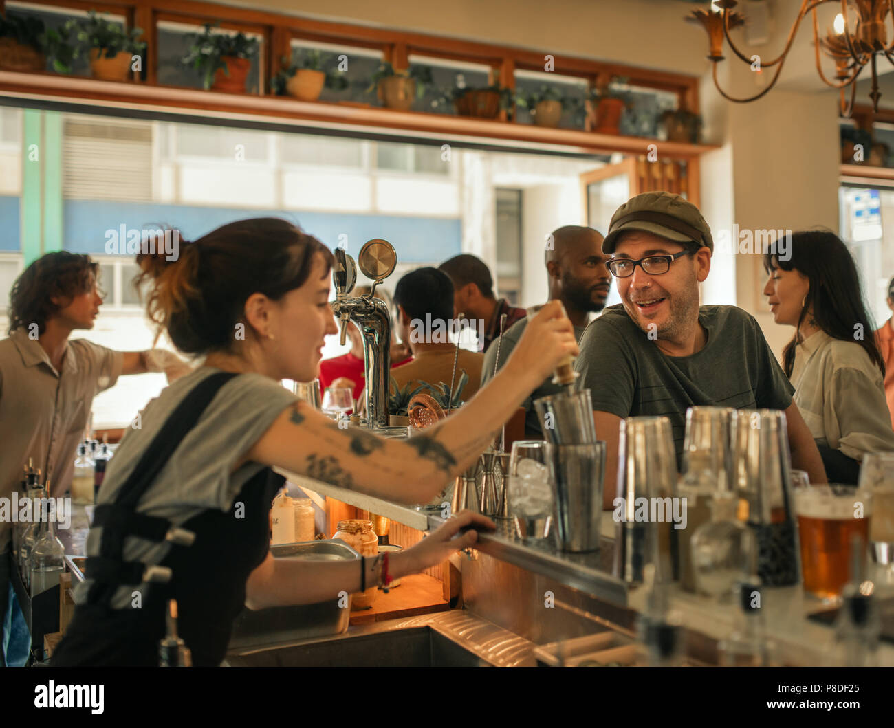 Smiling patron ordering drinks in a trendy bar Stock Photo