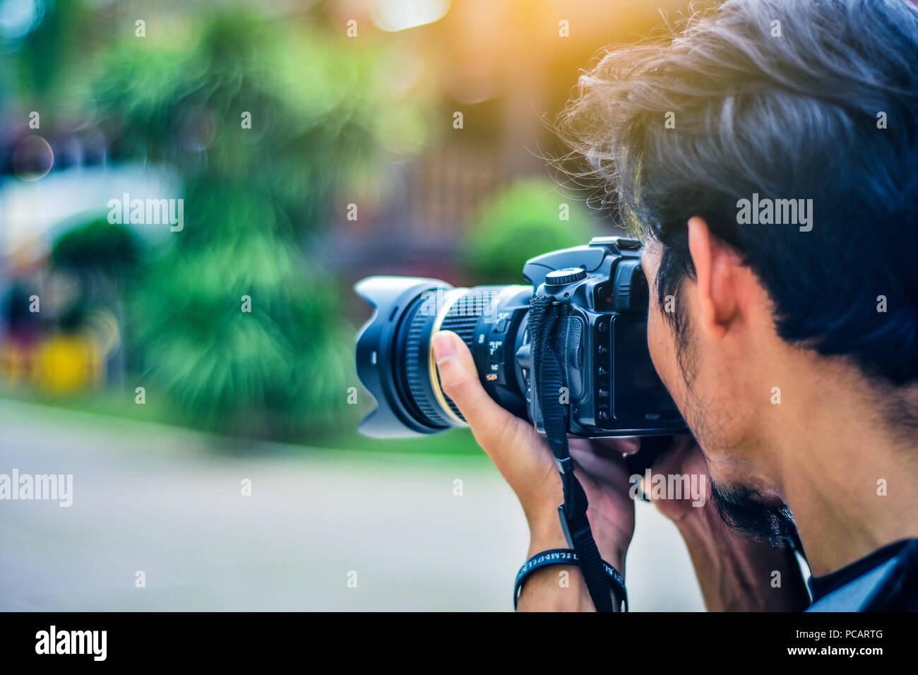 Man using camera DSLR taking photo sunlight background Stock Photo - Alamy