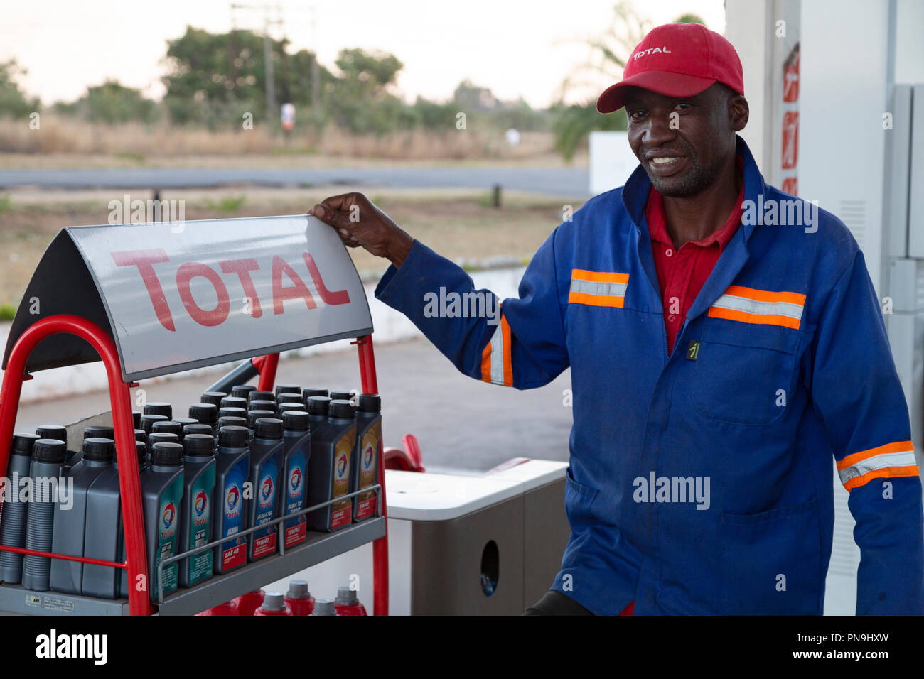 Mechanic at a garage in the east of Zimbabwe. The man wears a cap and blue coveralls. Stock Photo