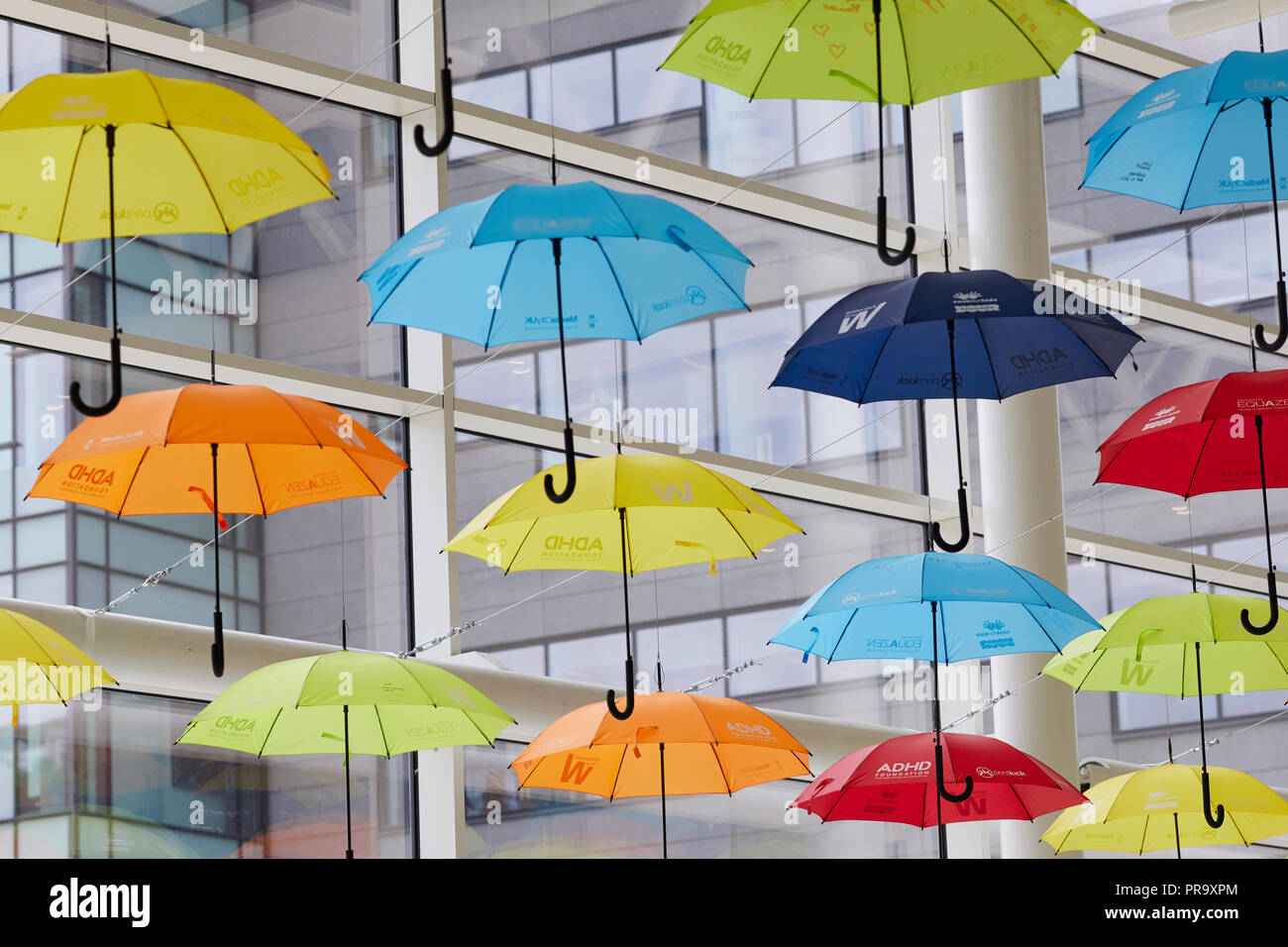 Brightly coloured umbrellas suspended in MediaCityUK Salford Quays to raise awareness of Attention Deficit Hyperactivity Disorder (ADHD) and autism Stock Photo