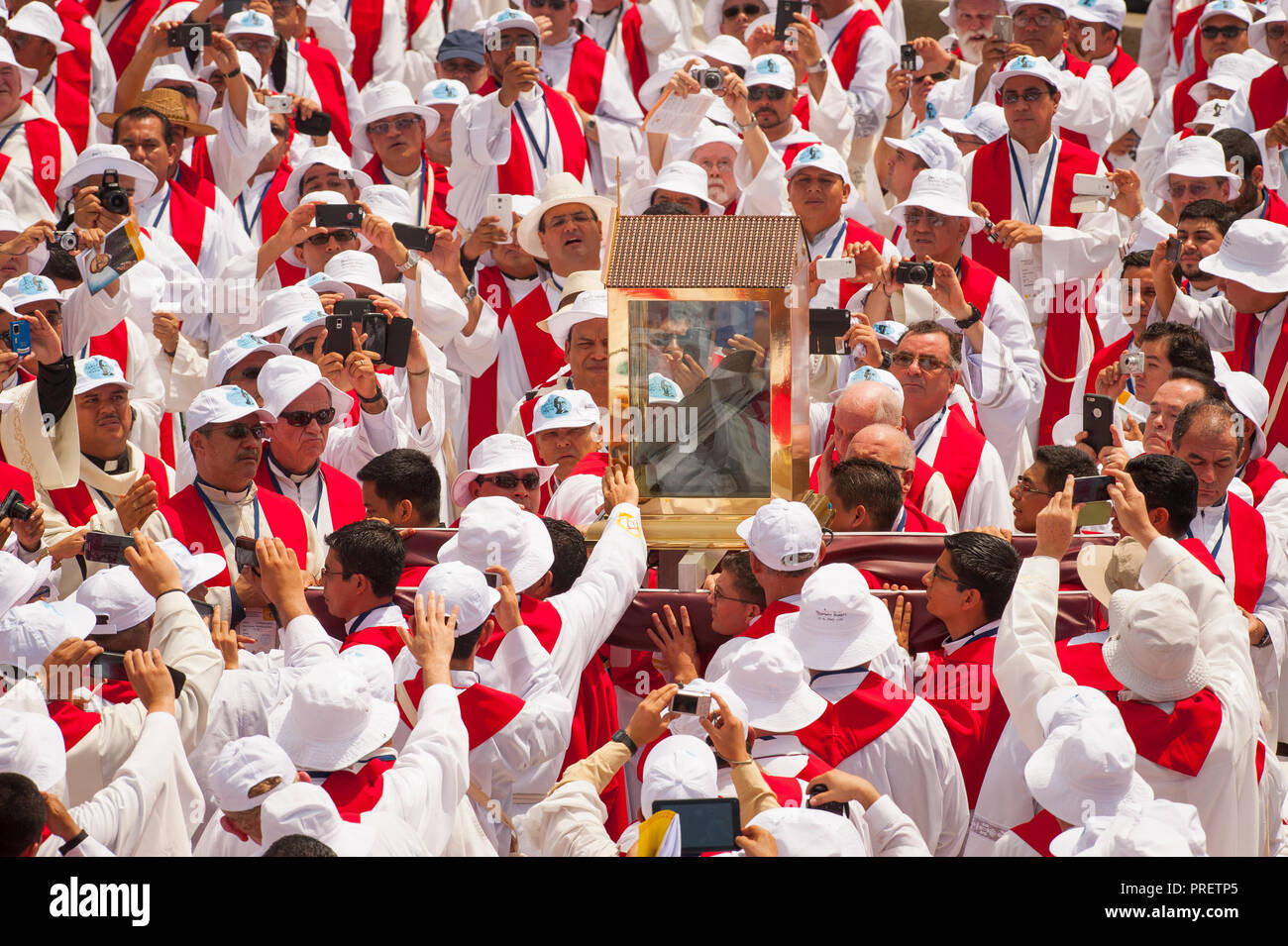 Salvadoran Catholic priests carry a relic - The blood stained shirt - of martyred Archbishop Oscar Romero  through a sea of priests.  The Archbishop was slain at the alter of his Church of the Divine Providence by a right wing gunman in 1980. Oscar Arnulfo Romero y Galdamez became the fourth Archbishop of San Salvador, succeeding Luis Chavez, and spoke out against poverty, social injustice, assassinations and torture. Romero was assassinated while offering Mass on March 24, 1980. Stock Photo