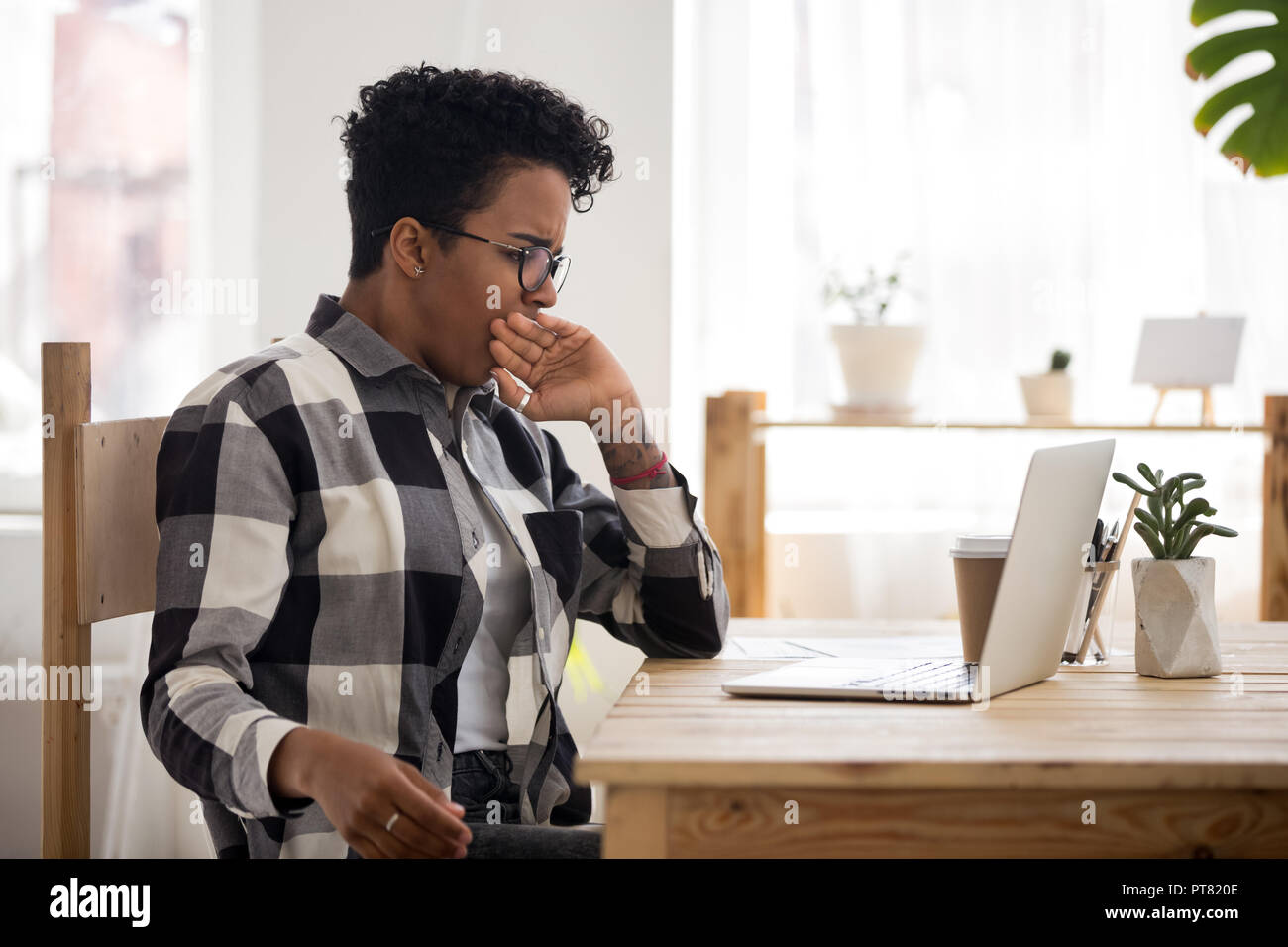 Bored black woman sitting at the desk  Stock Photo