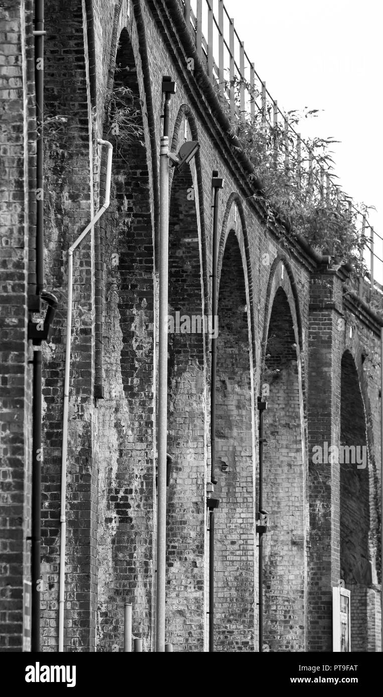 Black and white view of Victorian railway viaduct arches, Worcester City Centre, UK. Worm's-eye view of outside architecture. Stock Photo