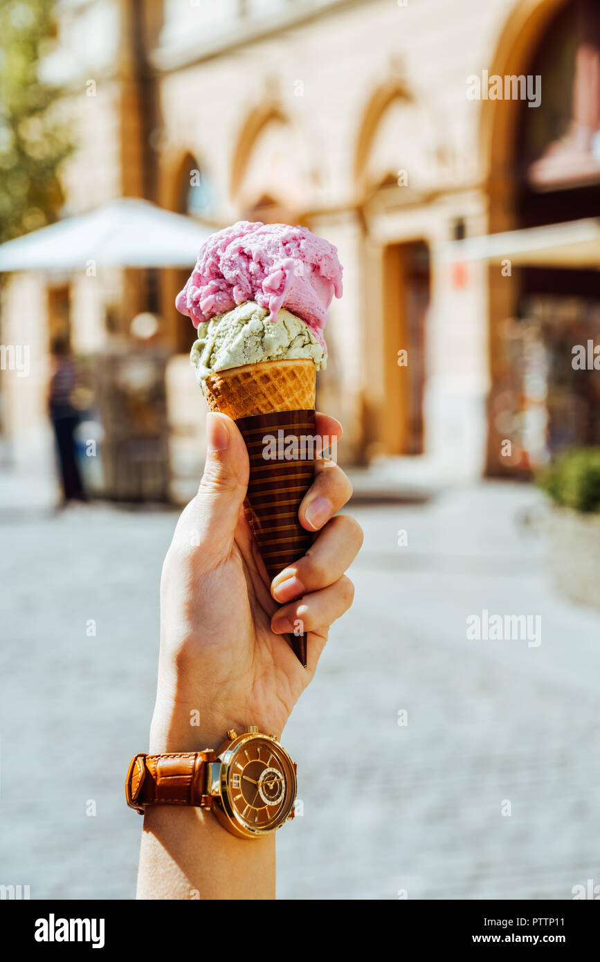 Woman Holding Green Pistachio And Pink Raspberry Ice Cream Cone In Hand Stock Photo