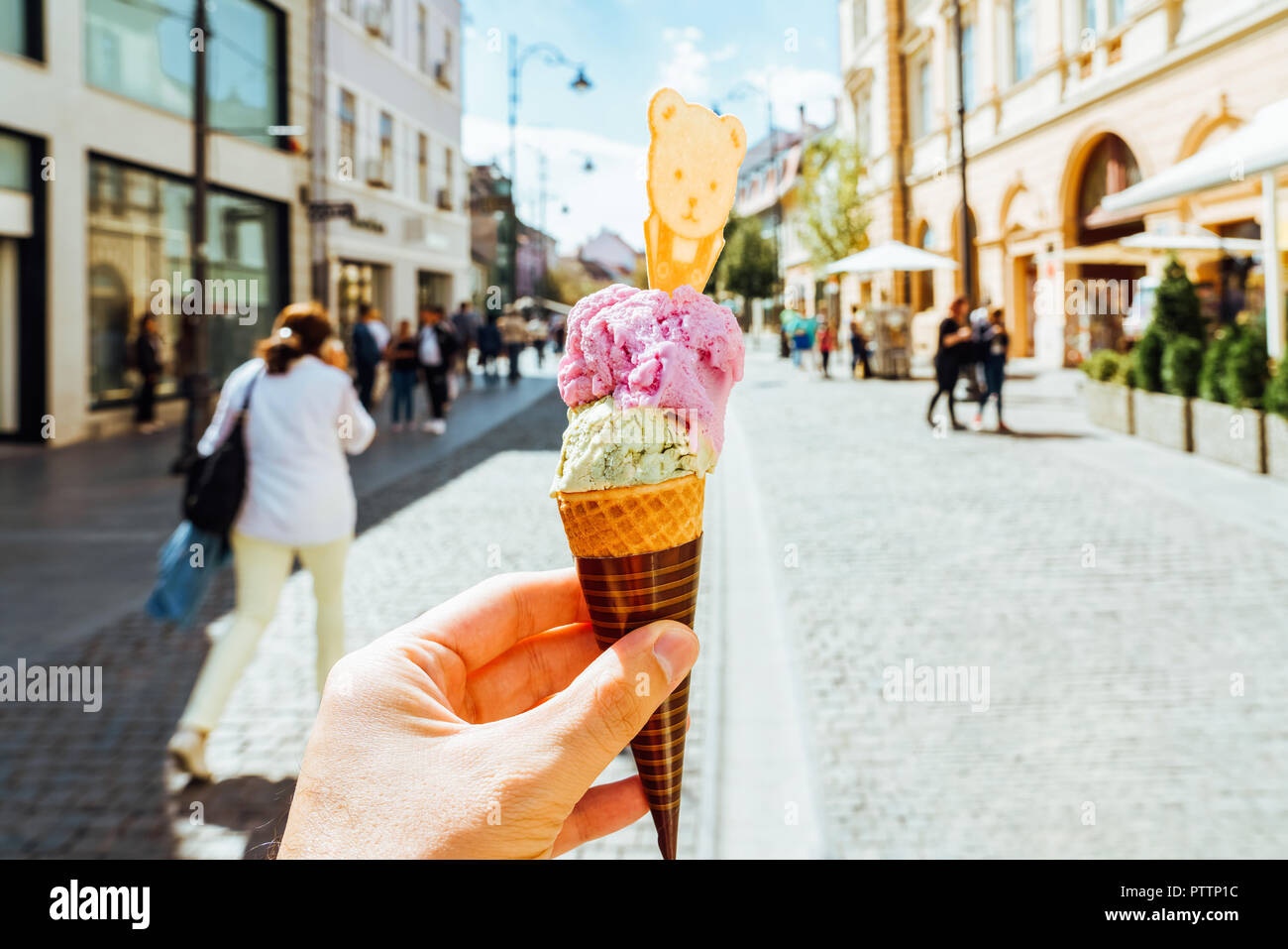 Man Holding Green Pistachio And Pink Raspberry Ice Cream Cone In Hand Stock Photo