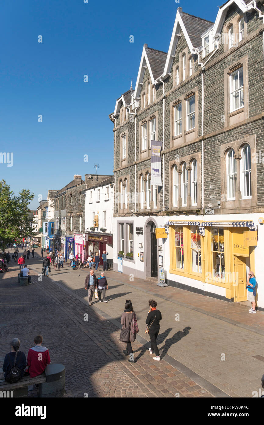 People walking down Keswick Main Street, past Joules of Keswick clothing store, Cumbria, England, UK Stock Photo