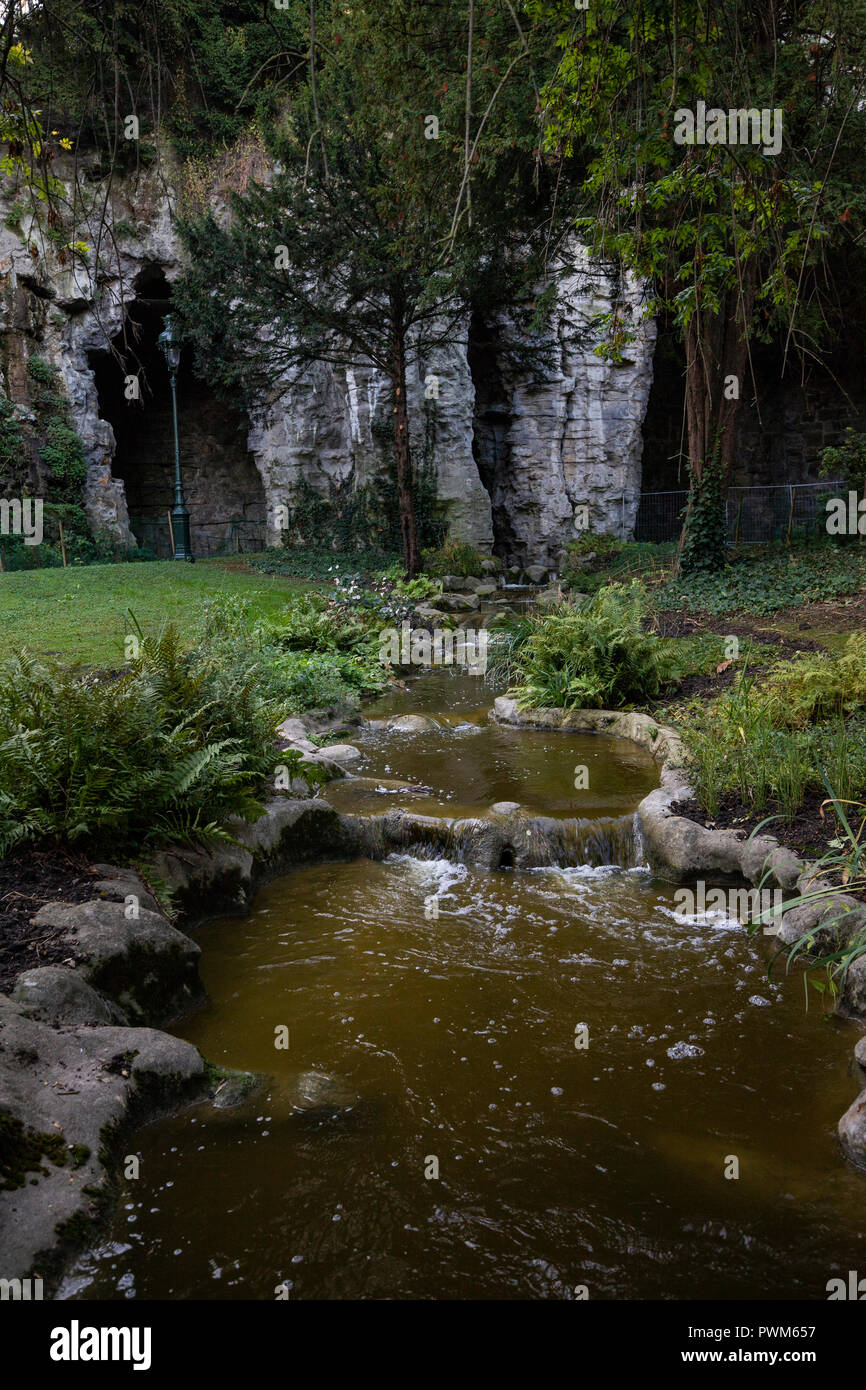 Waterfall at Buttes-Chaumont Park - Parc des Buttes-Chaumont is one of the most romantic parks in Paris. It was once a quarry, so there are many rock  Stock Photo