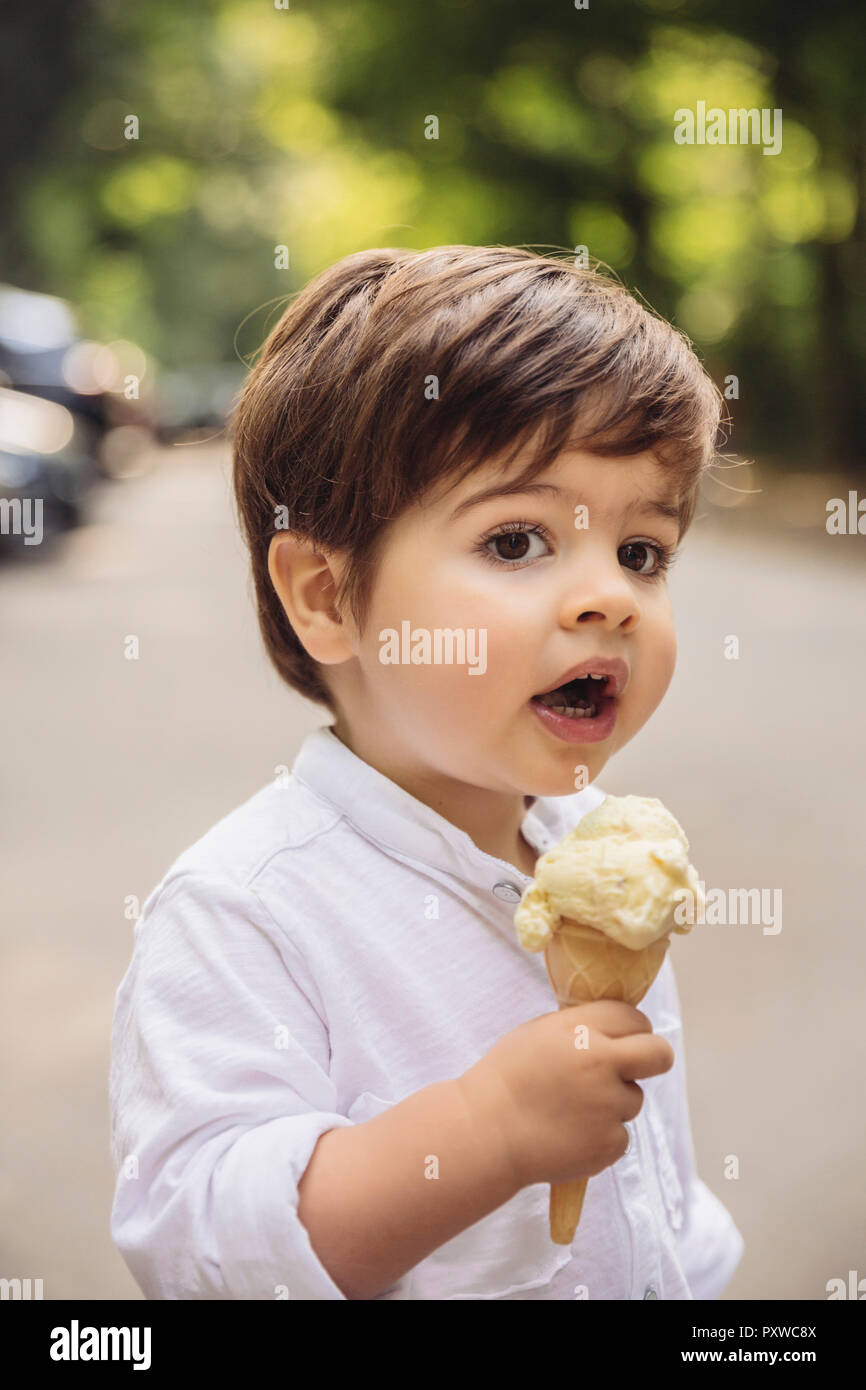 Portrait of toddler with vanilla ice cream cone in park Stock Photo