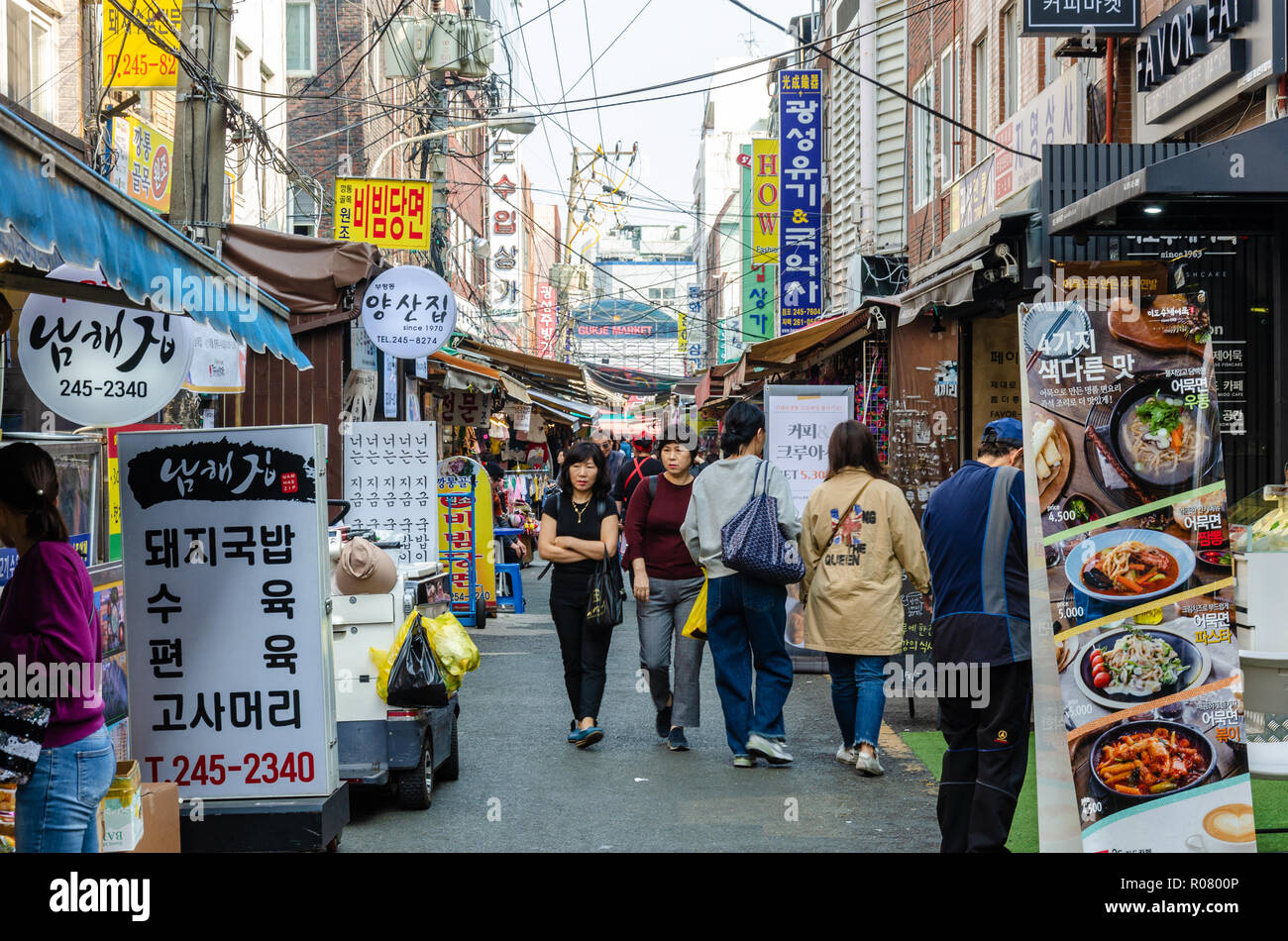 A view along a busy alley lined with stalls in the indoor market, Bupyeong Khangtong Market in Busan, South Korea. Stock Photo