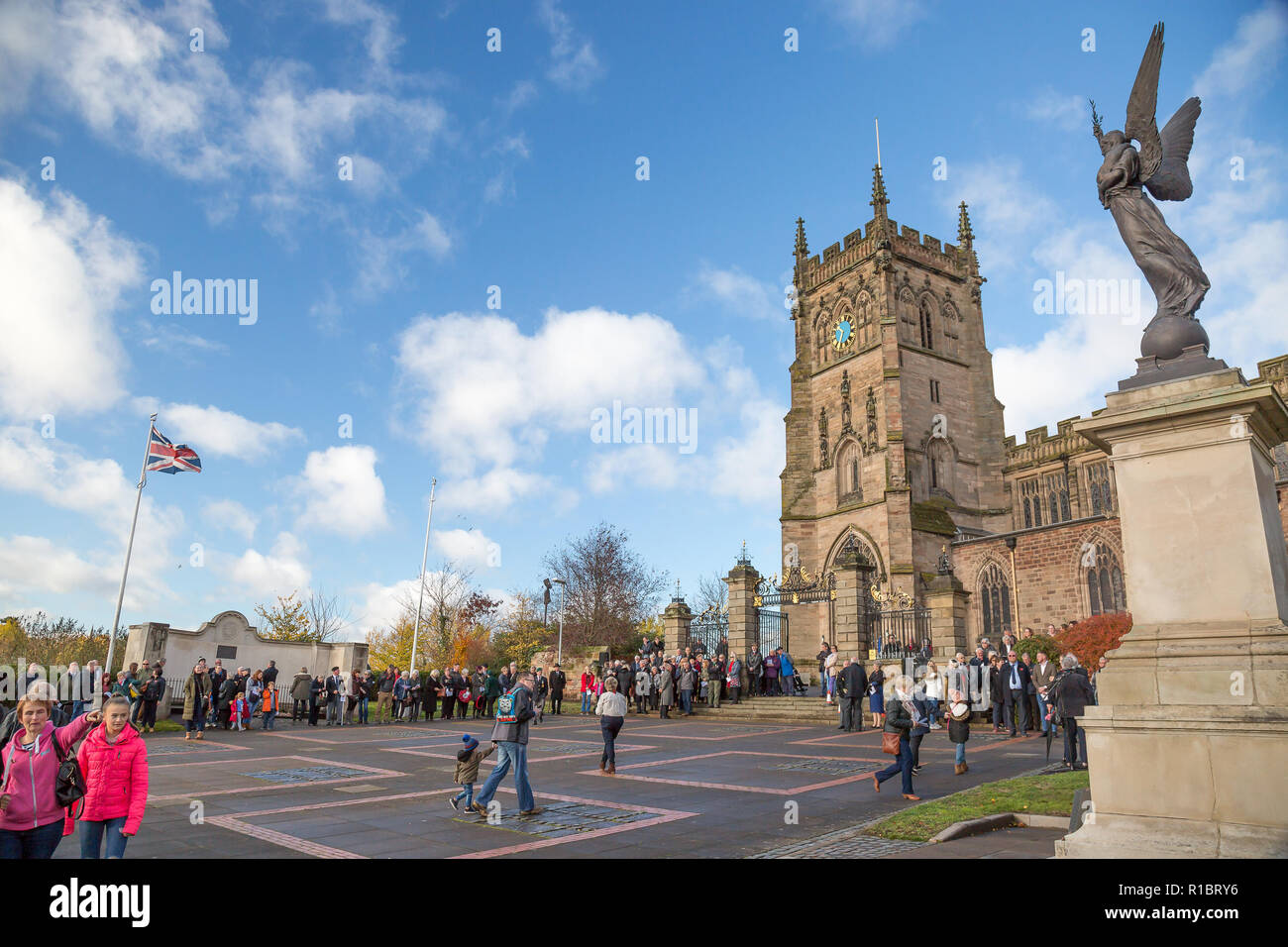 Kidderminster, UK. 11th November, 2018. With acts of remembrance taking place worldwide today, the people of Kidderminster come out in their hundreds to commemorate those who gave their lives for their country. On a gloriously sunny morning, crowds congregate at St Mary and All Saints Church, circling The Angel of Peace war memorial to pay their respects. Credit: Lee Hudson/Alamy Live News Stock Photo