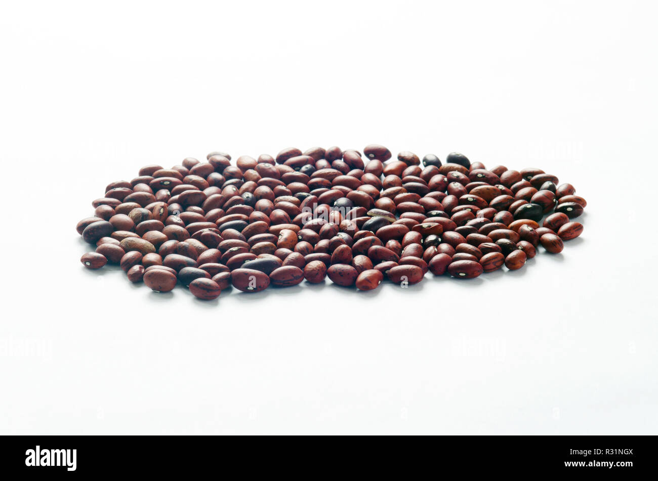 Small dried red beans on white, a good source of fiber and potassium Stock Photo