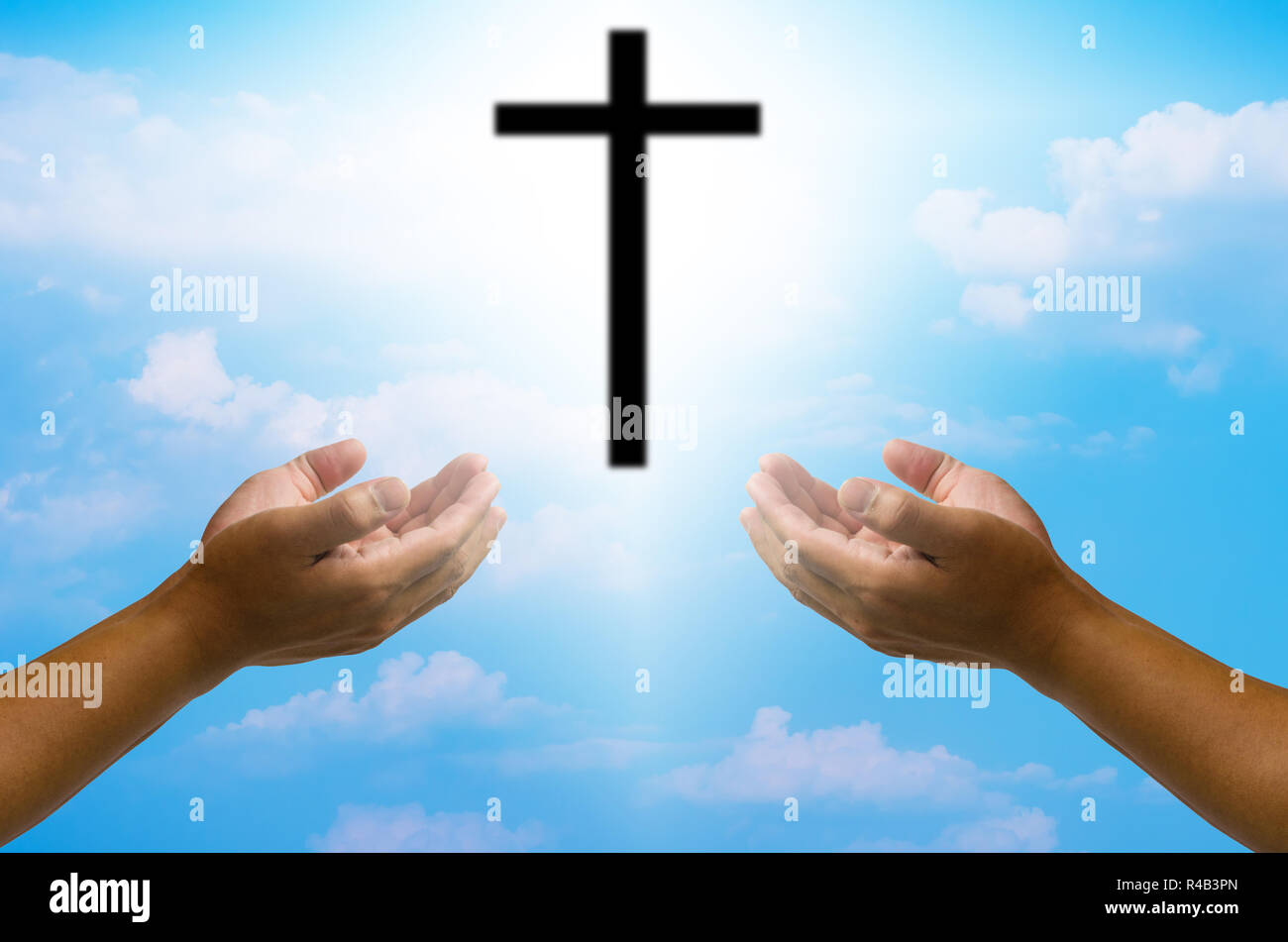 open hands praying the cross on blur sky background Stock Photo - Alamy