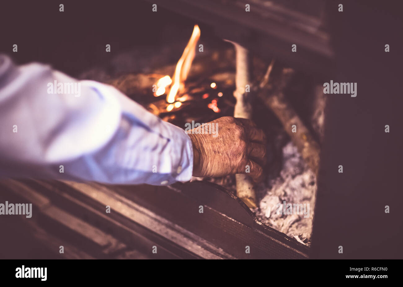 Man kindle a fire in the fireplace Stock Photo