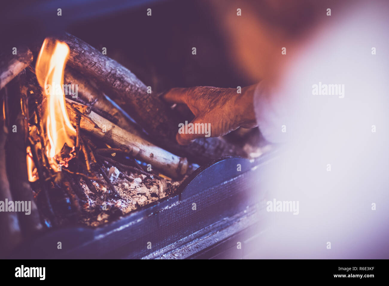 Man kindle a fire in the fireplace Stock Photo