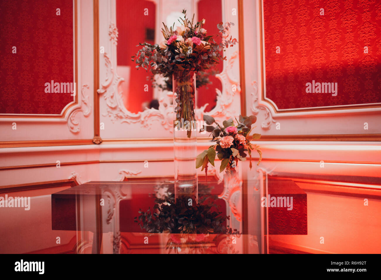 Hotel lobby in red color, decorated with a large vase of flowers. Stock Photo