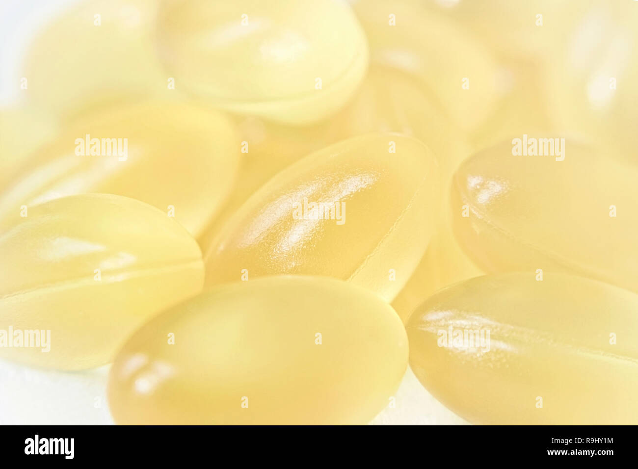 Yellow oval gelatin capsules fish oil pills medical texture Stock Photo