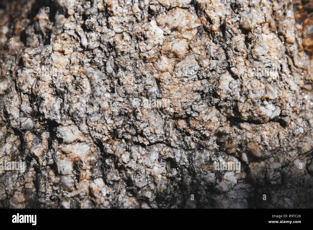 Close-up grungy rock textured with tiny glitter and shiny sharp pieces on the surface detail. Natural abstract background. Stock Photo