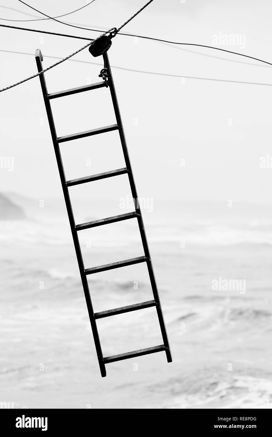 Ladder hanging from cables on the void Stock Photo