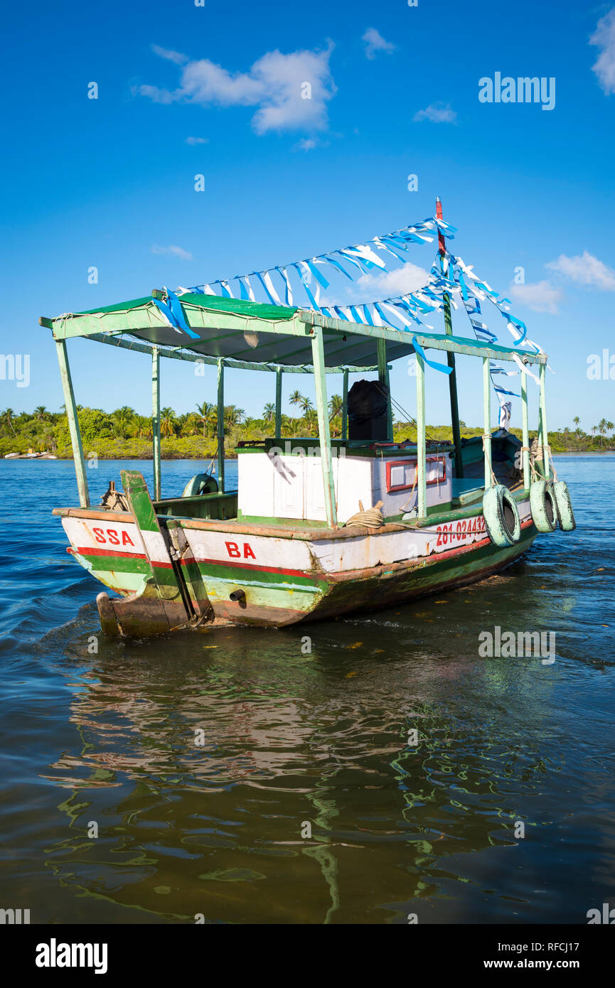 BAHIA, BRAZIL - FEBRUARY, 2016: An old-fashioned wooden Brazilian fishing boat is decorated with blue and white streamers in homage to Yemanja. Stock Photo