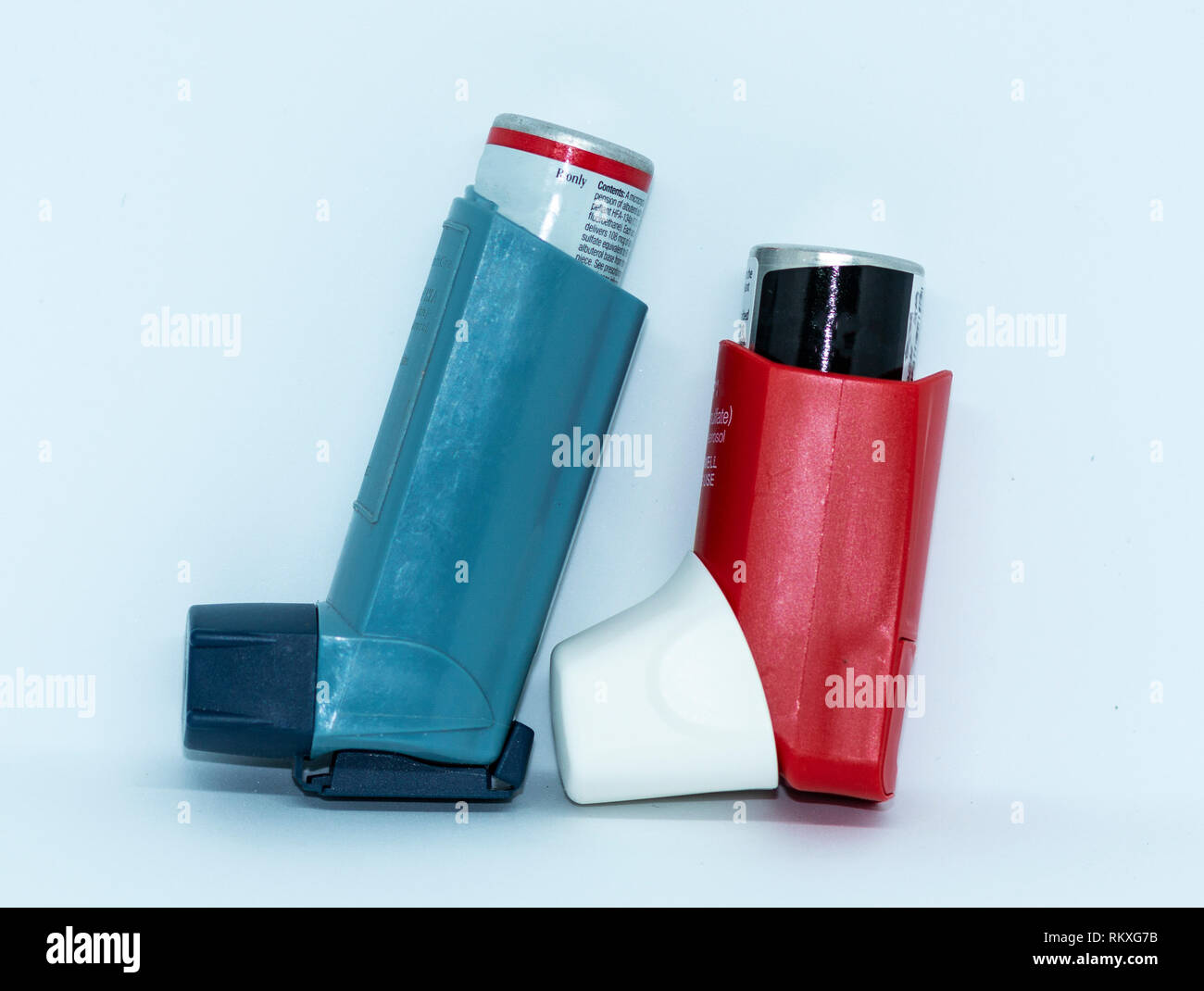 One blue and one red asthma rescue inhaler standing up with a white ...