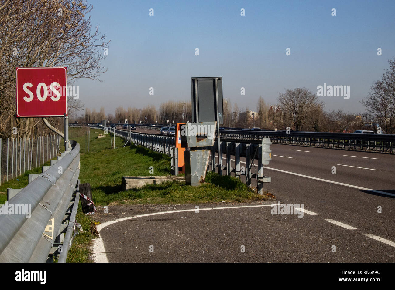 speed detector hidden behind a road barrier at an emergency stop on the highway Stock Photo