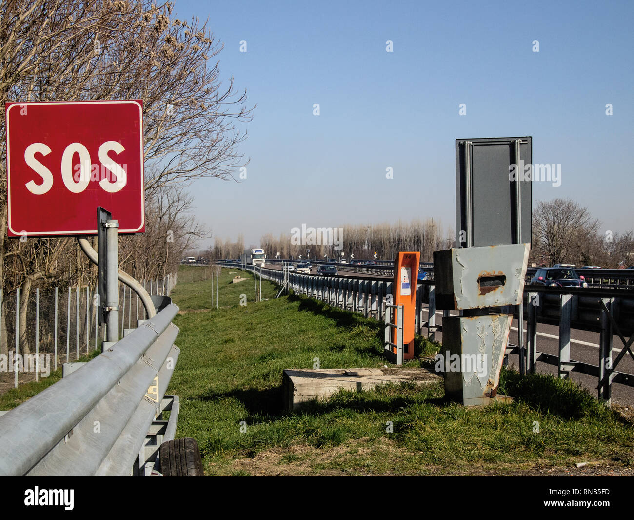 column with telephone in an emergency area on the highway and a hidden speed detector Stock Photo