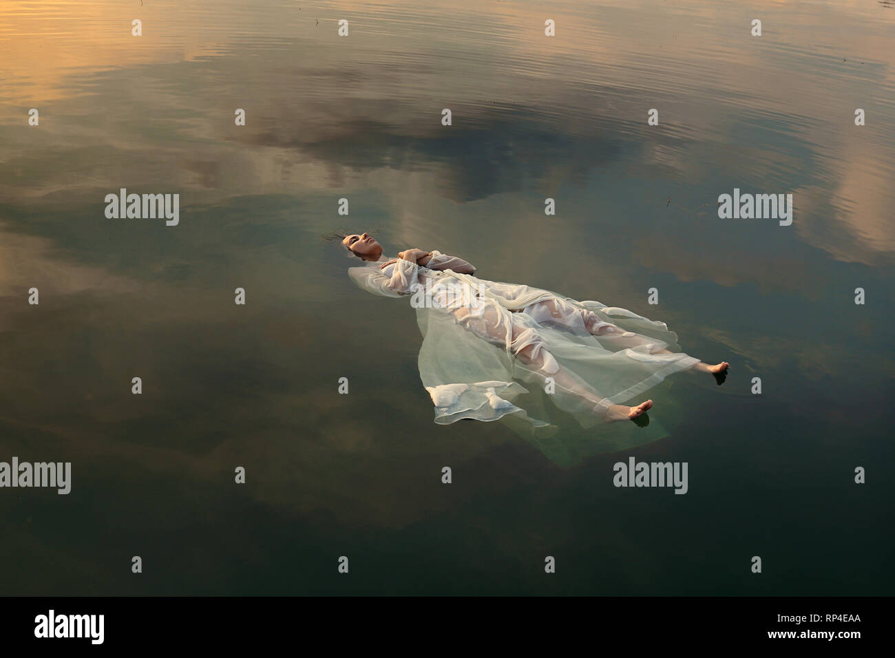 Floating dead bride in sunset colored waters Stock Photo