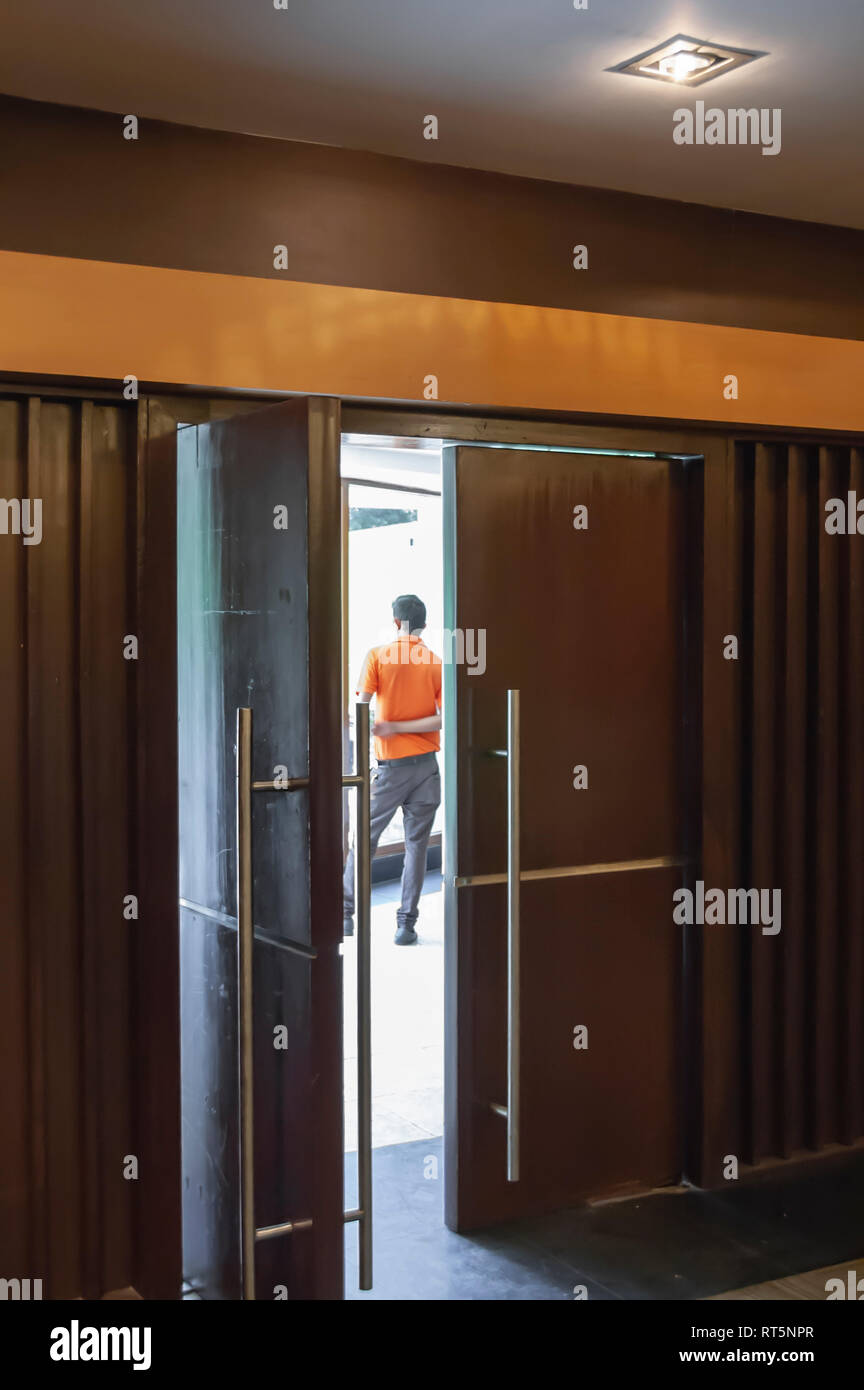 An attendant at a conference centre waiting for the participants to arrive. A frame within a frame-photographed through a partially open doorway. Stock Photo