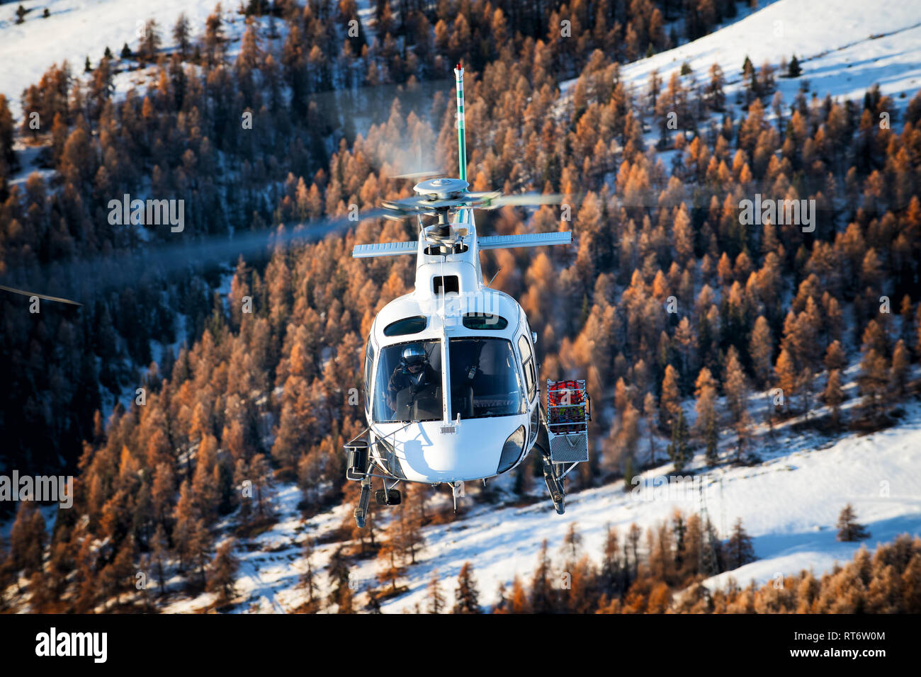 AS350 from AirGreen performing utility work in the Italian Alps. Stock Photo