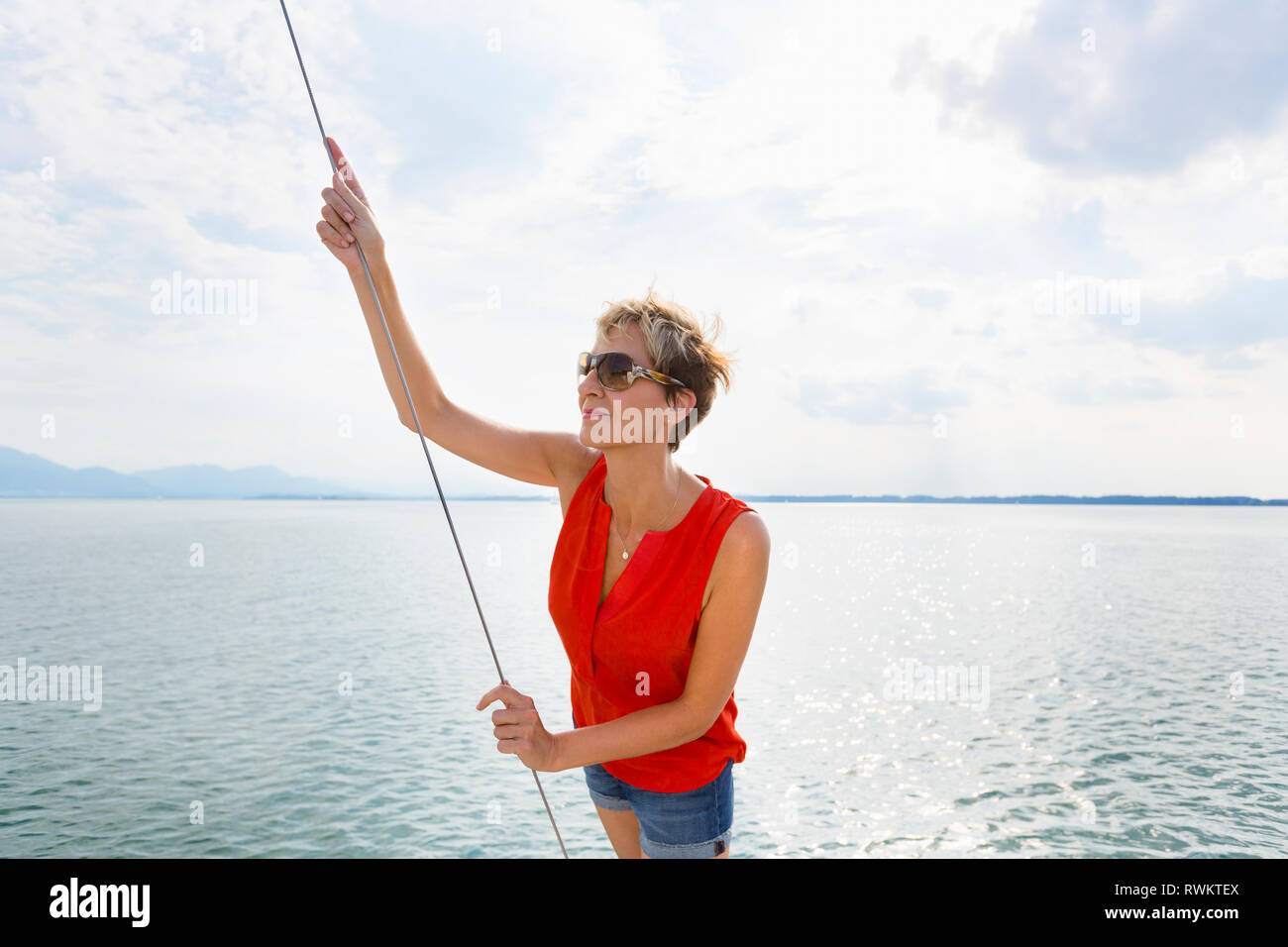 Mature woman sailing on Chiemsee lake, Bavaria, Germany Stock Photo