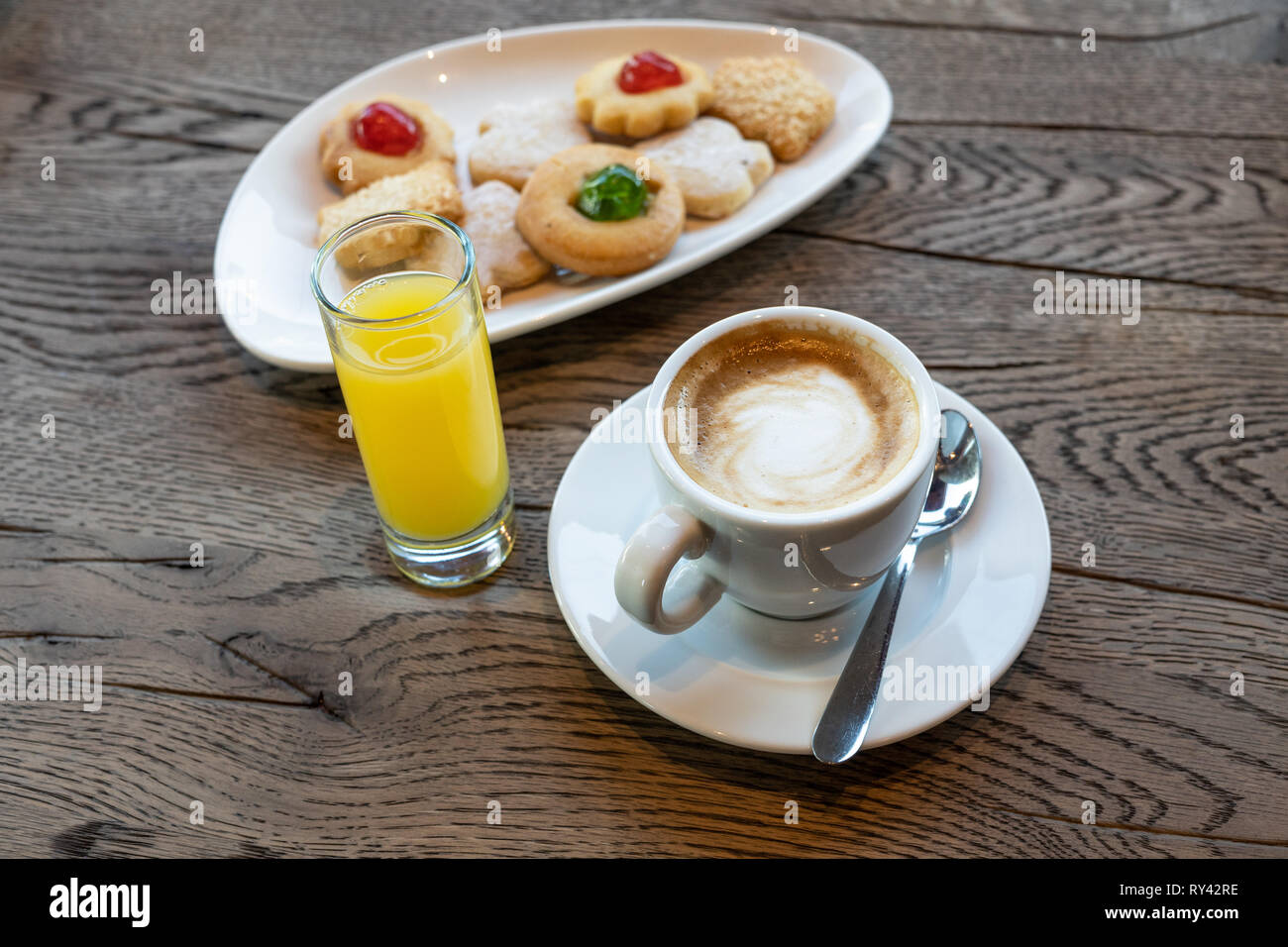 Cup of coffee, butter cookies and orange juice on wooden table Stock Photo