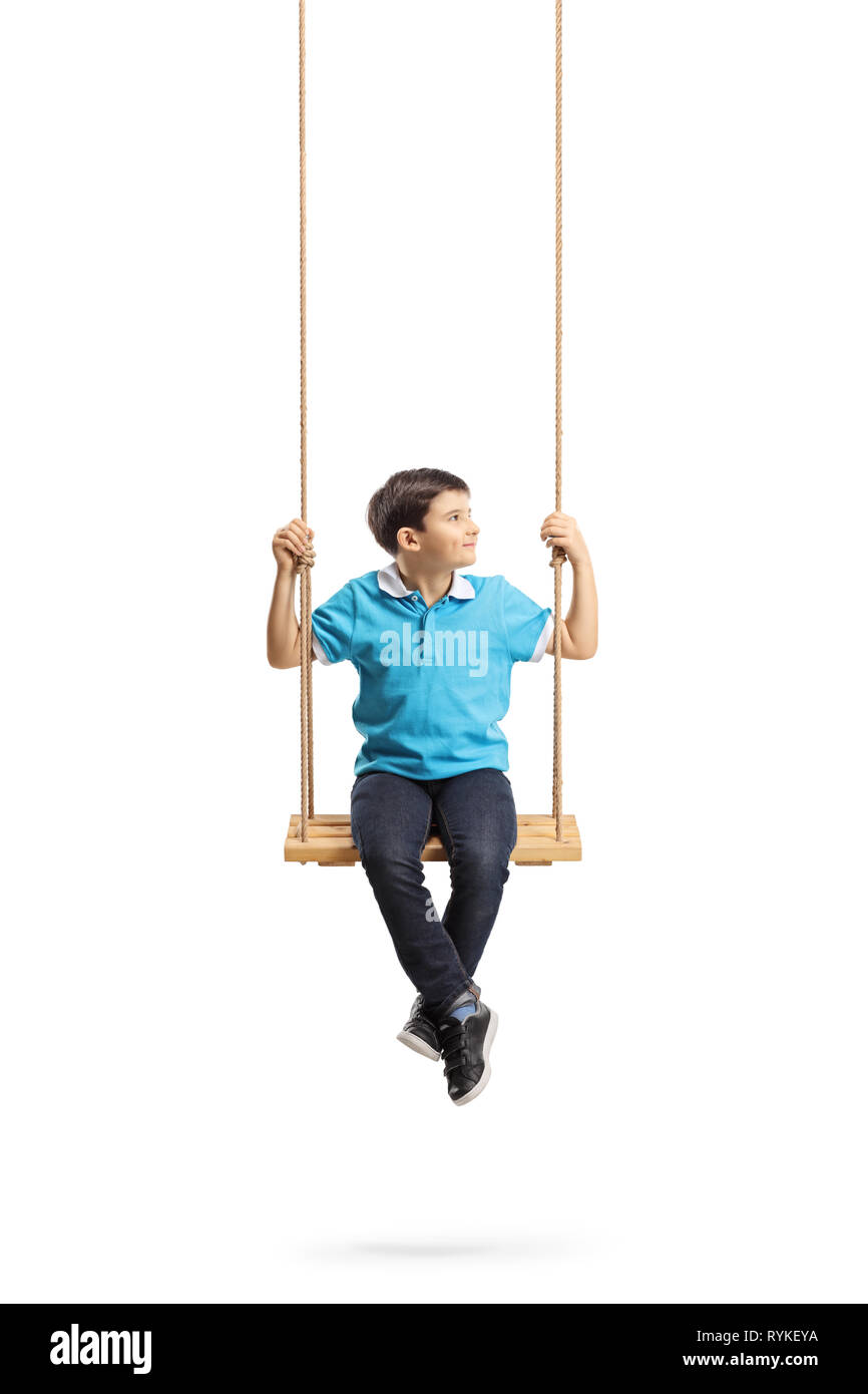 Full length portrait of a little boy sitting on a swing and looking to the side isolated on white background Stock Photo