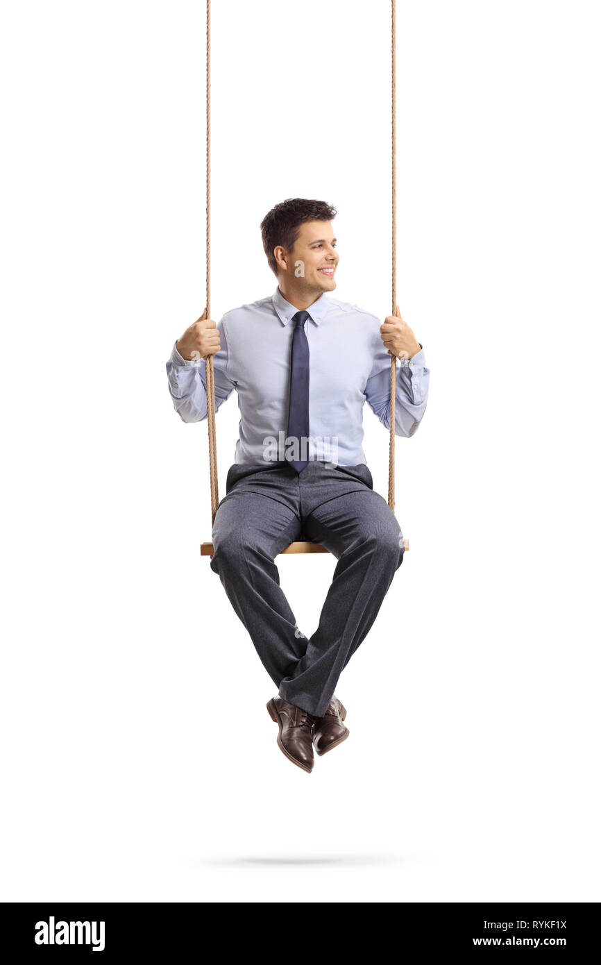 Full length portrait of a young professional man sitting on a swing and looking away isolated on white background Stock Photo