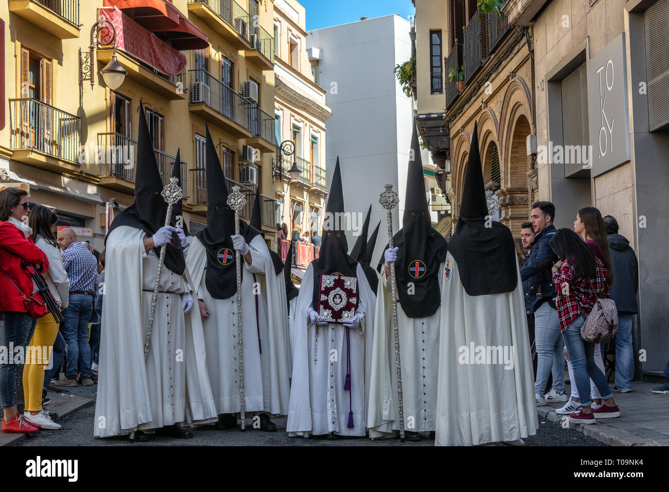 SEVILLE, SPAIN - MARCH 26:  People in white cloaks and black hoods in a Holy Week procession in Seville, Spain on March 26, 2018 Stock Photo