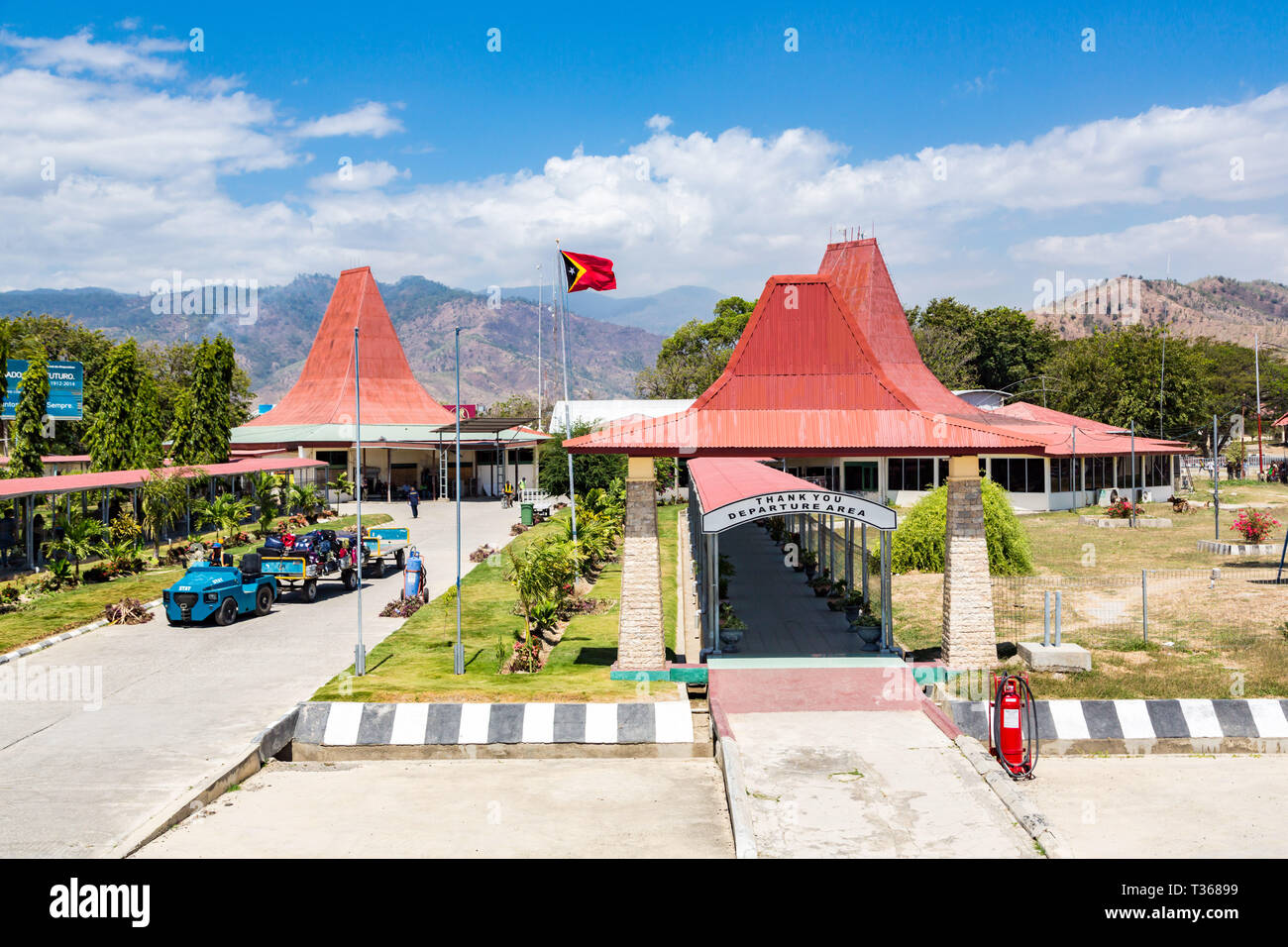 Dili, East Timor - Aug 10 2015: Presidente Nicolau Lobato - Comoro International Airport of Dili, Timor-Leste with national Timorese flag flying. Red  Stock Photo