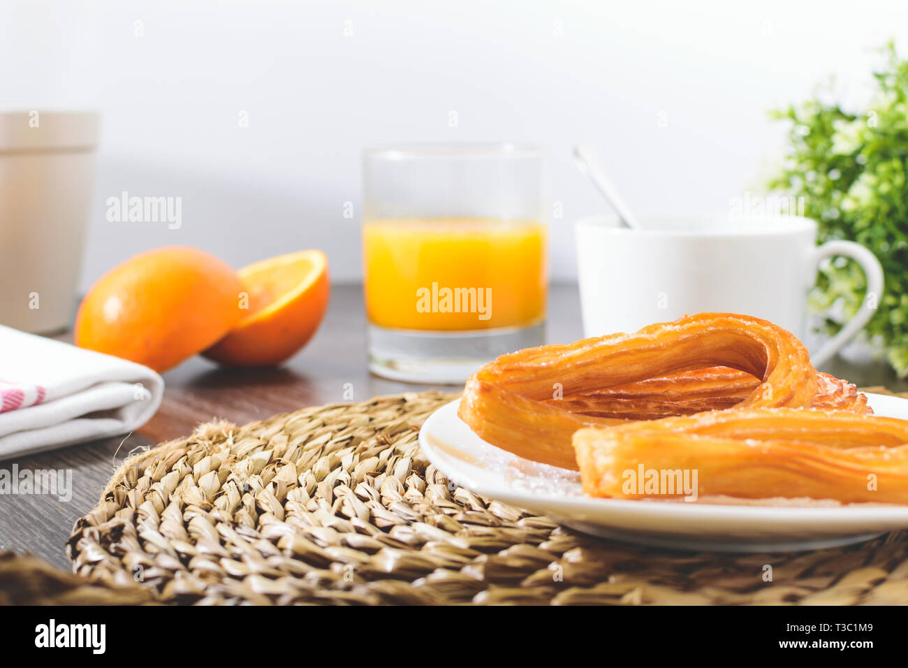 Tasty spanish churros, orange juice, coffee breakfast. Orange sliced. Tabletop with churros. White background Stock Photo