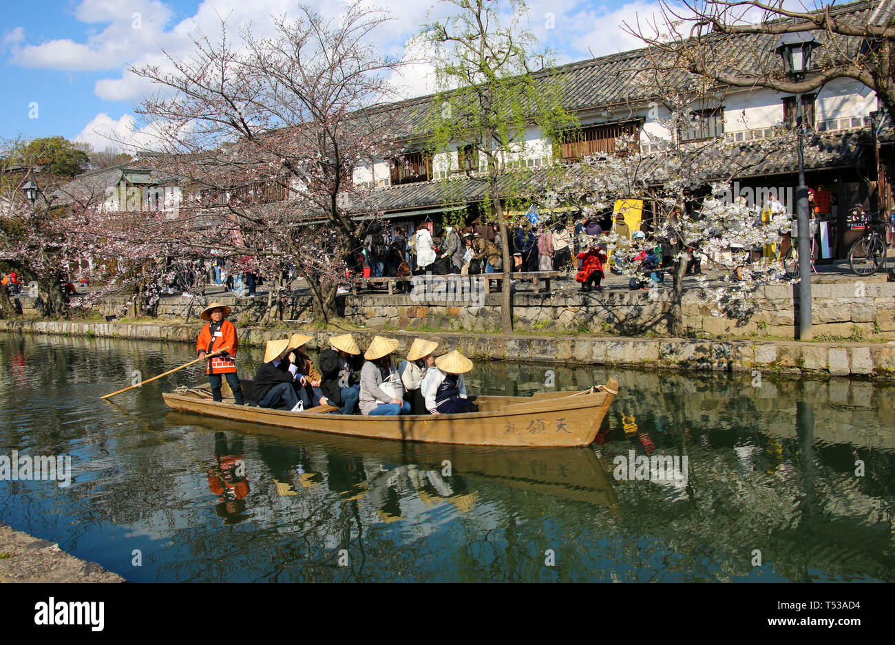 KURASHIKI, JAPAN - MARCH 31, 2019: Tourists are enjoying the old-fashioned boat along the Kurashiki canal in Bikan district of Kurashiki city, Japan. Stock Photo