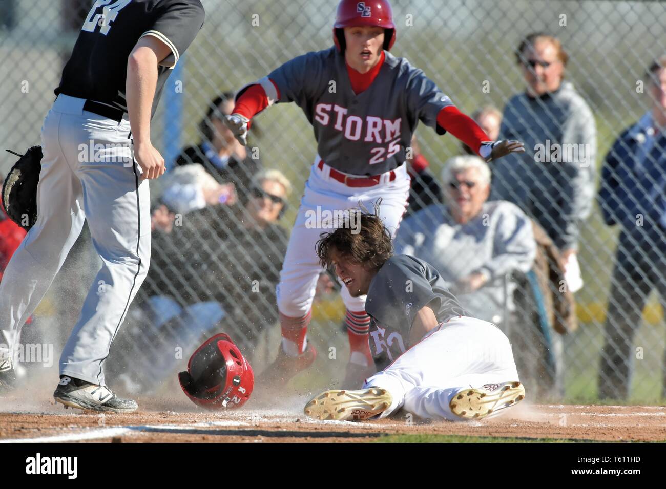 After eluding a rundown, a player scored with a head-first slide at the plate. USA. Stock Photo